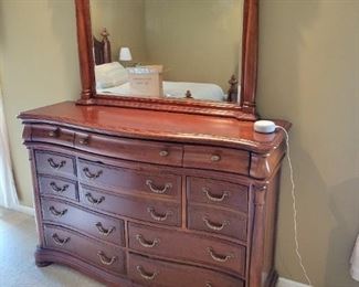 A solid wood bedroom set. Queen bed and bench as well as a high-boy dresser and long dresser with nightstands.  Dresser 60" W x 18 1/2" D x 42" H; mirror 46" W x 41" H