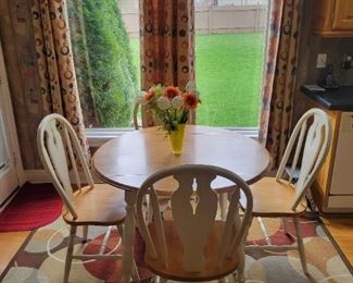 Round drop leaf table and chairs. Light wood with off white trim. Table top with leaves open 41" x 41" and 41" x 27" with leaves down, and 29 1/2" H