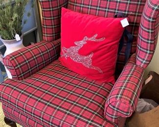 One of two red plaid wingback chairs