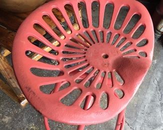 Repurposed metal tractor seat fashioned into a chair, painted in red