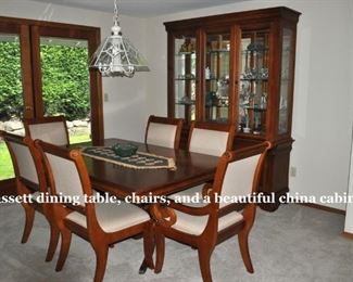 Basset dining table w/2 arm chairs and 4 side chairs, 44”x68”, plus two  18” leaves.  Bassett china cabinet 84” tall, 65.5” wide, 18” deep. Pristine condition!