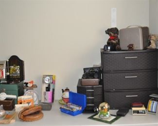 Camera equipment, one-armed bandit toy slot machine, projector, baseball mitt, cameras, storage drawers.