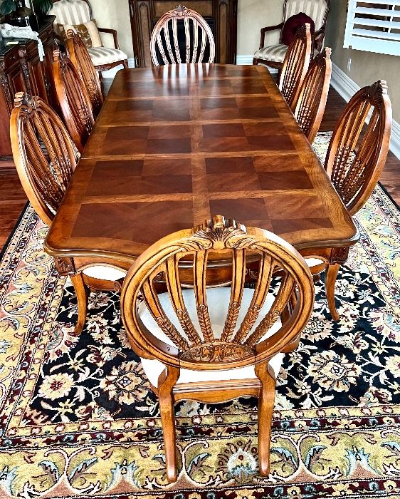 Statement Dining Room Table & Eight Chairs. This table is crafted in a beautiful timeless, classic design. It truly has a gorgeous appearance. 

The set includes eight chairs, two of which are host chairs. 

The table as shown has two leaves inserted and measures 106" x 44" x 30" (the two inserted leaves each measure 18"). With no leaves inserted, the table would measure at 70" x 44".  The table is in overall good condition with some light wear.