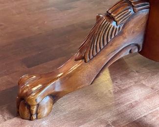 Pedestal Kitchen Table and Five Chairs measuring 54" in diameter and 31" high. The table has a lovely pedestal design featuring decorative clawed feet. The table has some wear to the finish including a single small hole drilled in the center of the table and some small dings. The chairs have some wear including scratch marks on the seats