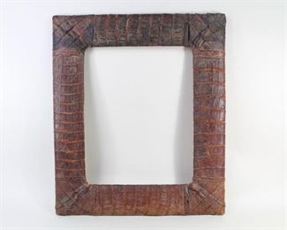 Lot 12: Antique Crocodile Hide Wrapped Picture Frame. Luxurious rectangular frame is made of wood, with the top surface being wrapped in brown crocodile hide. Wonderful for your home office or library.
Dimensions are 19.5 in h x 16.5 in w x .75 in d. Condition is good with wear and cracking to the skin. Please call or email for a detailed condition report.