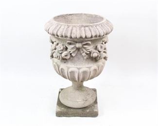 Lot 63: Large Floral Concrete Garden Urn Planter Jardiniere. Lovely planter is cast in 2 pieces (base & top), embellished with a ribboned floral garland and has nice patina and lichens from its time outdoors. Ready for its new life in your garden.
Dimensions are 19.5 in h x 20 in w x 20 in d. Condition is fair with chips and cracks throughout from exposure to the elements. Please call or email for a detailed condition report.