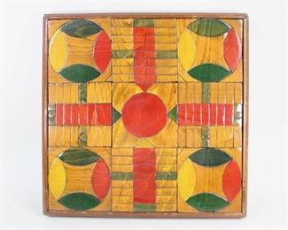 Lot 89: Folk Art Painted Wood Parcheesi Game Board. A beautiful, handmade Parcheesi game board made of individual stained wood blocks in red, blue, yellow and green. High gloss finish. Acquired in the 1980s in Connecticut. From the collection of Barbara Porter & Robert Wincuinas.

Dimensions are 16 in h x 16 in w x 2 in d. Condition is very good. Please call or email for a detailed condition report.