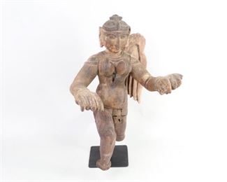 Lot 111: Colonial Indian Female Angel Hindu Deity Sculpture. A carved wooden sculpture of a female winged deity from Colonial era India. Her arms are outstretched and one leg moving forward and one back. Great patina with some paint residue. Possibly part of a decorative building panel. Mounted on a black stand. From the collection of Barbara Porter & Robert Wincuinas.

Dimensions are 18 in h x 9.5 in w x 13 in d. Condition is good. Overall surface wear scuffs and scratches. No feet and only one wing. Please call or email for a detailed condition report.
