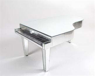 Lot 120: Liberace Style Mirrored Faux Piano Coffee Table. A fun coffee table in the shape of a small piano covered in mirror glass. One single sheet of glass make up the top while the sides and keys are made up by narrow rectangular pieces.

Dimensions are 17.26 in h x 24.5 in w x 41 in d. Condition is fair. Overall surface wear. Ware around and under keys. Some chips to glass edges. A few pieces have fallen off. Keys do not work. Please call or email for a detailed condition report.