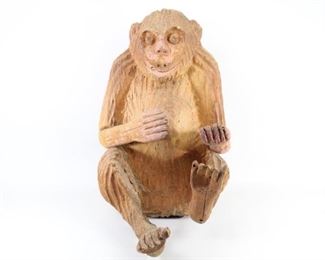 Lot 131: Roughly Carved Mexican Folk Art Chimpanzee Sculpture. A seated chimpanzee, roughly carved, with out stretched hands. Carved out of one piece of wood, with exception of the lower arms and feet, which have been added on. Partially drawn on and colored with pink in some areas. Made in the 1980s, Mexico. From the collection of Barbara Porter & Robert Wincuinas.

Dimensions are 24 in h x 15 in w x 19 in d. Condition is fair to good. Arms and feet are attached but slightly separated from body. One of the legs has been repaired at one point. Please call or email for a detailed condition report.