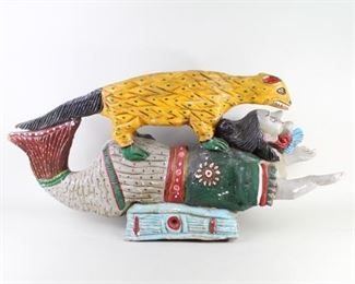 Lot 141: Mexican Carved Folk Art Sculpture of Mermaid & Coati. A carved wooden sculpture depicting a mermaid with an animal, possibly a Coati, riding on top of her back. Extensively carved and painted in bright colors. Acquired in the 1980s, Mexico. From the collection of Barbara Porter & Robert Wincuinas.

Dimensions are 19 in h x 38 in w x 12 in d. Condition is good. Please call or email for a detailed condition report.