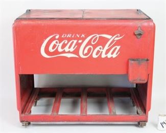 Lot 166: Large Red Embossed Coca Cola Icebox Cooler Chest. Includes built-in bottle opener and cap collector at upper right front. Bottom compartment for open storage and upper freezer compartment with hinged doors on top. All parts appear original, making for a great display piece. Text on side tells just how cold this icebox claims to keep your beverages: ICE COLD.

Dimensions are 35 in h x 40 in w x 25 in d. Condition is fair, with flaking paint and rust on interior and significant wear to paint, scratches, dents, grime, and wear to rubber seal. Please call or email for a detailed condition report.