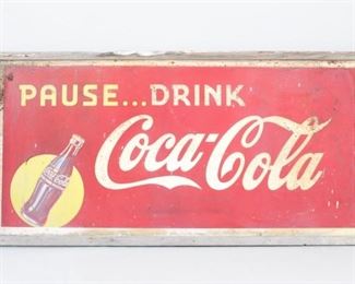 Lot 167: Large Pause Drink Coca Cola 1940s Tin Advertising Sign. Rectangular sign encourages you to "Pause...Drink Coca-Cola" and is framed in wood. Label on the back shows the sign was sent from Massillion Cleveland Arrow Sign Co to Hudson NY Coca Cola Bottling.
Dimensions are 35.75 in h x 71 in w x 2 in d. Condition is good to fair with rust, surface wear, paint loss, discoloration and damage to the wooden frame. Please call or email for a detailed condition report.