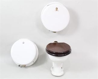 Lot 188: Victorian Antique Toilet & 2 Circular Tanks,Peerless(1/3). Toilet with wooden seat and lid, marked "Peerless," "Duquesne Sanitary Co Pittsburgh, PA," and "Pat'd. April 15, 1890 The T.P Company China Vitreous Trenton NJ." Lid has a metal plaque reading "Waterworks." The two tanks are in of a round pill box shape, one with a chromed metal flush and the other, with a brass flush, is missing its lid.

Dimensions for toilet are 19.5 in h x 15.5 in w x 22.5 in d. Dimensions for tanks are 20 in h x 18.5 in w x 8.5 in d. Condition is fair to good. 1 tank is missing lid. Toilet has a piece broken off at the base. Surface wear throughout. Wear to metal. Please call or email for a detailed condition report.