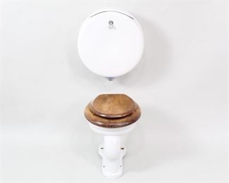 Lot 189: Victorian Antique Pillbox Porcelain Wood Toilet Set 2/3. Toilet with a light amber or walnut-stained wooden seat and lid. Wall-mounted tank has a round pill box shape, marked "MAC the Antique Plumber Inc, Sacramento, CA," with a chromed metal handle that says "PUSH." A luxurious piece of porcelain for your custom lavatory. The first of two such lots in this auction, this with a lighter wood stain.

Dimensions of toilet are 18 in h x 15.25 in w x 16 in d. Tank is 19 in h x 17.5 in w x 8.5 in d. Condition is very good, with minor surface wear throughout, some scuffs to lid and some discoloration. Please call or email for a detailed condition report.