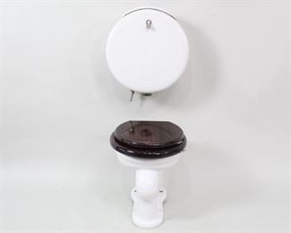 Lot 190: Victorian Antique Pillbox Porcelain Wood Toilet Set 3/3. Toilet with very dark stained wooden seat and lid, marked "Waterworks". Wall-mounted tank has a round pill box shape, lid marked "MAC the Antique Plumber Inc, Sacramento CA," with a chromed metal handle. A luxurious piece of porcelain for your custom lavatory. The second of two similar water closet sets in this auction.

Dimensions of toilet are 18 in h x 15.25 in w x 16 in d. Tank is 19 in h x 17.5 in w x 8.5 in d. Condition is very good, with minor surface wear throughout, a chip to the tank lid, and some marks on lid and minor discoloration. Please call or email for a detailed condition report.