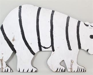 Lot 197: Naive Folk Art Wood Cut Bear Sign in Black & White. A charming wood cut of a bear, painted on both sides, black on one side and white on the other. The naively painted figure may have functioned as a double-sided sign, as it has two holes in the legs for mounting. Could be used as a sign or as a lovely piece of decoration in a children's room. 

Dimensions are 30 in h x 47 in w x 0.75 in d. Condition is fair. Wear to paint and cracks in wood. Please call or email for a detailed condition report.