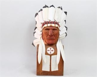 Lot 259: Carved Folk Art Bust of a Native American Plains Chief. A wonderfully carved bust of a Native American chief. All fourteen feathers of the headdress are individually carved and removable. Acquired in the 1980s, near Boston. From the collection of Barbara Porter & Robert Wincuinas.

Dimensions are 33 in h x 16 in w x 15 in d. Condition is very good to excellent. Cracks running through the back. Please call or email for a detailed condition report.