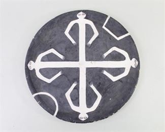 Lot 293: B&W Native Figural Earthenware Clay Plate. A decorative plate, painted black with four white stylized figures arranged in a cross, facing the four directions. The back is painted white. Possibly of Native American or South American origin.

Dimensions are 12.75 in h x 12.75 in w x 1 in d. Condition is fair to good. Surface wear, wear to edges. Chipped spots and some paint loss. Please call or email for a detailed condition report.
