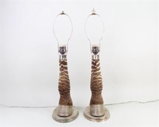 Lot 306: 2 Burchell Zebra Taxidermy & Sterling Silver Lamps. A pair zebra leg and hoof taxidermy table lamps. Set on sterling silver bases with sterling silver top mount. 

Dimensions are 23 in h x 5.5 in w x 8.25 in d. Condition is good. Surface wear and tarnish to silver. Seems on back of legs are loose and coming undone. One lamp is missing a finial. The lamps have not been tested for function, may need to be rewired. Please call or email for a detailed condition report.