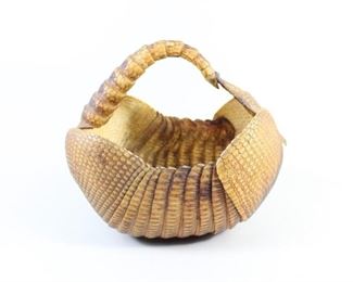 Lot 312: Armadillo Shell Basket, Southwest Folk Art,Taxidermy. Clever basket is made of an armadillo shell; its tail wraps over to create the handle. Place on a pedestal as sculpture, use as a basket to hold your needlework project, or even use as a centerpiece, filled with seasonal goodies.
Dimensions are 10.25 in h x 9.5 in w x 7.25 in d. Condition is very good with minor surface wear. Please call or email for a detailed condition report.
