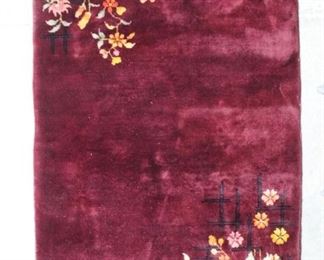 Lot 349: Chinese Art Deco Burgundy Rug w/Yellow Floral Motif. Art Deco wool rug with a burgundy base and floral motifs in opposite corners. The florals are woven in yellow, orange and pink colors, set on a black architectural grid.

Dimensions are 35 in h x 58 in w x 0.5 in d. Condition is very good. Minor surface wear. Please call or email for a detailed condition report.