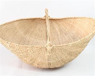 Lot 399: Oversize Woven Palm Basket w/Handle from Bali. A giant basket made in woven palm from Bali. The handle, in rattan or cane, continues throughout the sides and bottom and offers extra support. For storage, decor or would be great for a retail store. From the collection of Barbara Porter & Robert Wincuinas.

Dimensions are 33 in h x 54 in w x 31 in d. Condition is very good to excellent. Please call or email for a detailed condition report.
