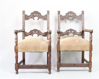 Lot 415: Pair of Carved Oak Jacobean Revival Style Arm Chairs. Pair of open arm chairs with ornately carved backs and turned front legs and arms. Thick, upholstered seats in a fish bone patterned fabric.

Dimensions are 39.75 in h x 20 in seat h x 22 in w x 22 in d.  Condition is good. Surface wear throughout and some discoloration. Please call or email for a detailed condition report.