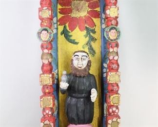 Lot 421: Mexican Folk Art Polychrome Altar Wall Alcove Shrine. An alcove shrine from Mexico made of carved wood, plaster and canvas. The central figure, St Francis of Assisi, is holding a dove in his right hand. Three plaques with cherubs surround him and a larger head is carved on the bottom. Painted in bright colors with floral motifs. The St Francis figure is not original to the shrine and can be removed. Acquired in the 1980s, Mexico. From the collection of Barbara Porter & Robert Wincuinas.

Dimensions are 47 in h x 17 in w x 11 in d. Condition is good. Overall surface wear, paint chipping. Some cracks and discoloration. Please call or email for a detailed condition report.

