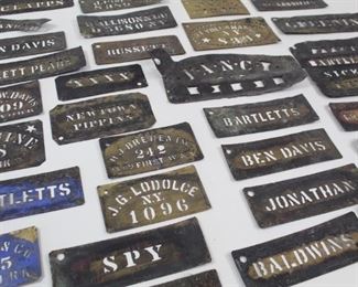 Lot 432: Lot of 38 Metal Stencils, NY Orchards Apples & Pears. Fascinating lot os antique stencils include many apple & pear varieties, including Spy, Ben Davis, Jonathon, Baldwin, Bartlett, Sickle, Greening, Wealthy and more. Other stencils have names and New York. Amazing collection is stored in a wooden Kraft cheese box.
Dimensions range from 2.75 in h x 7 in w to 4.75 in h x 11 in w. Condition is good to fair with lots of wear, worn metal, many dents; some are more damaged than others. Please call or email for a detailed condition report.