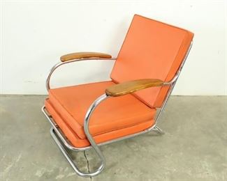 Lot 463: Art Deco Tubular Chrome Orange Vinyl Armchair Lloyd Mfg. Nice lounge chair with a sleek modern look and in a desirable orange color. Frame is made of tubular chrome, and cushions of orange vinyl. Partial label from Lloyd Manufacturing remains.
 
Dimensions are 29 in h x 27.25 in w x 35 in d. Condition is good with some surface corrosion on the metal tubes and small hairline cracks on the wooden armrests. Please call or email for a detailed condition report. 

