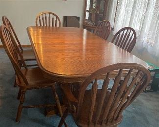 Nathan Hale solid oak dining table with six chairs. Comes with table pads and two leaves. 65 inches long by 42 inches wide. Each leaf 11 inches. Total length with leaves 64 inches long