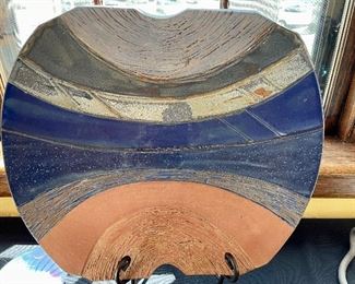 $200; signed original, abstract pottery sculpture with varying textures and colors; 20”w x 18”h. (Plate stand not included. )