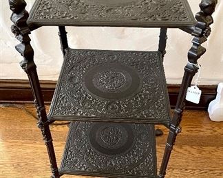SOLD - $120; detailed, lightweight, metal table with three shelves and busts as finials and claw feet; 14”w x 14”d x 31”h