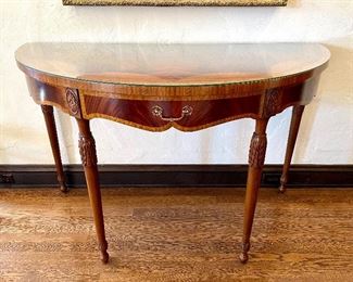 SOLD - $1800; Stunning demilune Maitland-Smith table with one drawer and detailed carvings. Perfect veneer; glass top; in pristine condition; 52”w x 26”d x 34”h