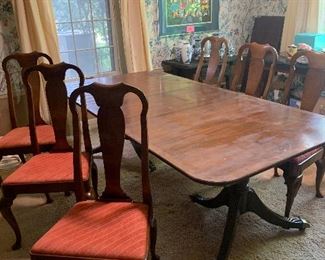 In the dining room there is a Baker dining room table with three leaves and a set of eight, six sides and two arm chairs, Baker dining room chairs.