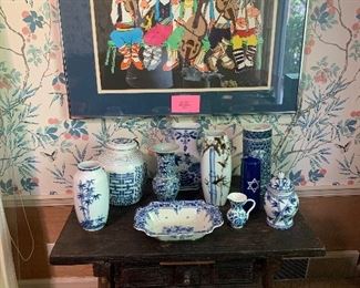 A antique hand made Spanish table holding a collection of blue and white. Above is "Five Musicians" signed and numbered art work by French painter and lithographer Jovan Obican.