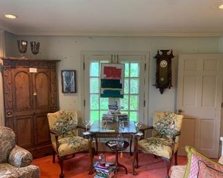 Look into the sunroom, a corner English pine cabinet, with a pair of English chairs covered in Scalamandre fabric flank an English game table, books to learn bridge and chest.