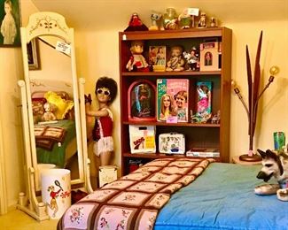 Here is the whimsical upstairs bedroom. Lot's of vintage toys, 1950's era table light fixture, vintage child store mannequin. twin size bed with Ralph Lauren denim comforter, Burlington House vintage swivel mirror to match bed headboard, side table, and hutch. Signed Vanna White doll, Buffy from "Family Affair" styling head, Rin Tin Tin plush dog.