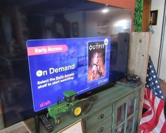 65 inch working color TV. Samsung with remove. Green server buffet table below TV.