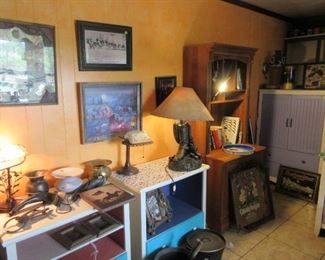 Bookshelf, night tables, lamps, wall art, cast iron items. Lots of collectibles in this room.