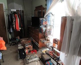 Bedroom full of assorted items, collectibles, books, clothing, dresser, wardrobe, sleep number q/s bed. area rug. lots more.