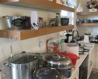 Kitchen counters are loaded with kitchen items.