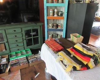 Green 5 drawer server (has TV on top) painted corner cabinet. Lots of CD's, VHS, DVD,s. Indian style throws and blankets, beer steins and loads more.