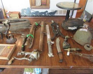 Primitive tools, WWII helmet, horse collar, in background against the wall is a nearly 5 foot metal (heavy) cut out of horses and stagecoach.