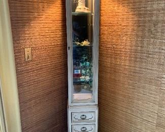 Lighted cream French Provincial pencil thin Curio cabinet, glass shelves and a trio of drawers 