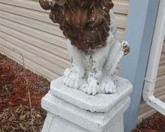 Concrete lion statue on base.