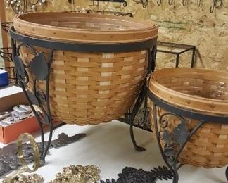 Longaberger planter baskets with wrought iron stands, cast iron brackets, and decor.