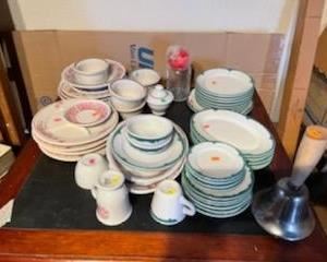 large variety of dishes, restaurant ware as well as many stainless steel serving pieces and serving trays. then a large bell so they hear when dinner is ready!