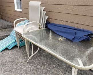 Large glass top patio table and 4 chairs--pads sold separately--umbrella and stand sold seperately
